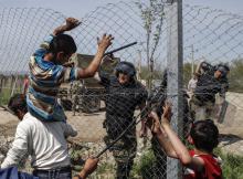 A Macedonian policeman uses his baton to prevent migrants and refugees to open the border fence at a makeshift camp at the Greek-Macedonian border near the village of Idomeni, Greece, April 7, 2016. PHOTO BY REUTERS/Marko Djurica