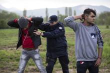 Migrants, who said they were from Syria, are being apprehended by the Serbian border police for having illegally entered the country from Macedonia, near the town of Presevo some 383 km (238 miles) from capital Belgrade, Serbia, April 29, 2015. PHOTO BY REUTERS/Marko Djurica