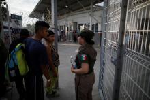 Migrants from Honduras, part of a new caravan from Central America trying to reach the United States, talk with a Mexican immigration officer on the border bridge between Mexico and Guatemala immigration in Ciudad Hidalgo, Mexico, January 17, 2019. PHOTO BY REUTERS/Jose Cabezas