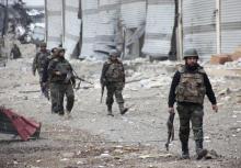 Forces loyal to Syria's President Bashar al-Assad walk with their weapons in the Aleppo town of Naqaren, after claiming to have regained control of the town
