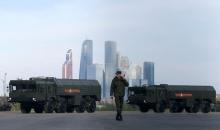A Russian serviceman walks past Russian Iskander-M missile launchers before a rehearsal for the Victory Day parade, with the Moscow International Business Center also known as "Moskva-City" seen in the background, at a range in Moscow, Russia, May 5, 2016. PHOTO BY REUTERS/Maxim Shemetov