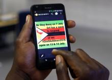 A man checks a message on his mobile phone, in Harare, Zimbabwe, July 7, 2016. PHOTO BY REUTERS/Philimon Bulawayo