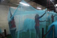 Workers look for holes in mosquito netting at the A to Z Textile Mills factory producing insecticide-treated bednets in Arusha, Tanzania, May 10, 2016. PHOTO BY REUTERS/Katy Migiro