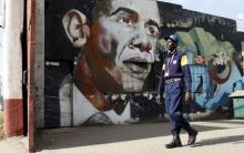A security guard walks past a wall mural depicting U.S. President Barack Obama outside the Go-Down Art Centre in Kenya's capital Nairobi, July 17, 2015. PHOTO BY REUTERS/Thomas Mukoya