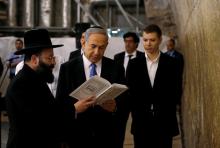 Israel's Prime Minister Benjamin Netanyahu (C) reads a prayer with Western Wall Rabbi Shmuel Rabinowitz (L) as his son Yair (R) stands next to him, at the Western Wall, Judaism's holiest prayer site, in Jerusalem's Old City, March 18, 2015. PHOTO BY REUTERS/Ronen Zvulun