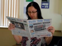 A hotel receptionist reads a local newspaper in Tamuning, Guam, a U.S. Pacific Territory, August 12, 2017. PHOTO BY REUTERS/Erik De Castro