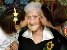 The World's oldest woman, Jeanne Calment, 120 years old, is kissed by two young girls during a special ceremony in a retirement home in Arles, Southern France, February 21, 1995. PHOTO BY REUTERS/Jean-Paul Pelisser