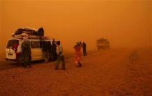 Passengers stand outside their taxi after a sandstorm raised by the annual dry ''Harmattan wind''