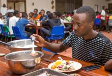 Ruhumuriza Vincent De Paul, who was orphaned by genocide, puts a meal on a plate in the dinning hall at the Agahozo-Shalom Youth Village (ASYV) built to rehabilitate children who lost their families in the 1994 Rwandan genocide, in Rwamagana, Eastern Province of Rwanda, April 1, 2019. PHOTO BY REUTERS/Jean Bizimana