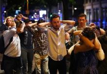 People leave the area with their hands up after an incident near London Bridge in London, Britain, June 4, 2017. PHOTO BY REUTERS/Neil Hall