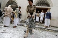 A Houthi militant collects evidence at the site of a car bomb attack near an Ismaili mosque in Yemen's capital Sanaa, July 29, 2015. PHOTO BY REUTERS/Khaled Abdullah