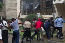 People gather to pull a hose after a fire broke out at the headquarters of the Nigeria Football Federation in Abuja