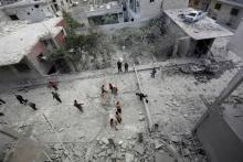 People inspect the damage at a site hit by airstrikes in the rebel-controlled area of Maaret al-Numan town in Idlib province. PHOTO BY REUTERS/Khalil Ashawi