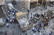 People clean a site from the rubble after it was hit by shelling carried out by rebels at Syrian government-held areas of Aleppo, Syria, in this handout picture provided by SANA, July 11, 2016. PHOTO BY REUTERS