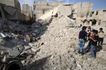 People inspect a damaged site after airstrikes in the rebel held Karam Houmid neighbourhood in Aleppo, Syria, October 4, 2016. PHOTO BY REUTERS/Abdalrhman Ismail