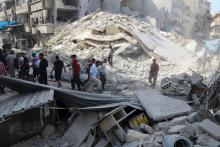 People inspect the damage at a market hit by airstrikes in Aleppo's rebel held al-Fardous district, Syria, October 12, 2016. PHOTO BY REUTERS/Abdalrhman Ismail