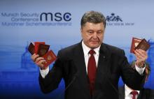 Ukraine's President Petro Poroshenko holds Russian passports to prove the presence of Russian troops in Ukraine as he addresses during the 51st Munich Security Conference at the 'Bayerischer Hof' hotel in Munich, February 7, 2015. PHOTO BY REUTERS/Michael Dalder