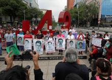 Relatives pose with images of some of the 43 missing Ayotzinapa College Raul Isidro Burgos students in front of a monument of the number 43, during a march to mark the 41st month since their disappearance in the state of Guerrero, in Mexico City, Mexico, February 26, 2018. PHOTO BY REUTERS/Henry Romero