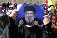A supporter of Lebanon's Hezbollah leader Sayyed Hassan Nasrallah carries his picture during a rally marking al-Quds Day, (Jerusalem Day) in Maroun Al-Ras village, near the border with Israel, southern Lebanon, June 8, 2018. PHOTO BY REUTERS/Aziz Taher