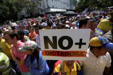 An opposition supporter holds a placard that reads "No more dictatorship" as he takes part in a rally against Venezuela's President Nicolas Maduro's government in Caracas, Venezuela, April 1, 2017. PHOTO BY REUTERS/Marco Bello