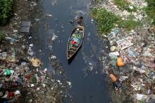 A man on a boat collects plastic materials from dirty water in Dhaka, Bangladesh, April 17, 2019. PHOTO BY REUTERS/Mohammad Ponir Hossain