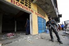 A police officer stands guard in front of a store that was looted during violent protests in Kinshasa, Democratic Republic of Congo, January 23, 2015. PHOTO BY REUTERS/Rey Byhre