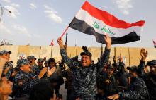 A member of Iraqi Federal Police waves an Iraqi flag as they celebrate victory of military operations against the Islamic State militants in West Mosul, Iraq, July 2, 2017. PHOTO BY REUTERS/Erik De Castro