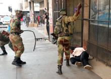 Soldiers beat a supporter of the opposition Movement for Democratic Change party of Nelson Chamisa outside the party's headquarters as they await the results of the general elections in Harare, Zimbabwe, August 1, 2018. PHOTO BY REUTERS/Mike Hutchings