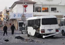 A police special unit arrives to inspect the police patrol mini bus which was hit by explosions at a police checkpoint in the village of Dih, west of Manama