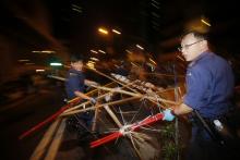 Policemen remove a barricade at a protest site in Mongkok shopping district in Hong Kong