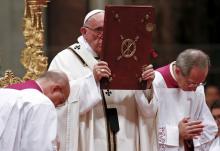 Pope Francis holds the book of the gospels as he leads the Christmas night mass in Saint Peter's Basilica at the Vatican, December 24, 2015. PHOTO BY REUTERS/Tony Gentile