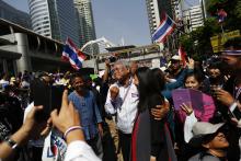 Protest leader Suthep Thaugsuban (C) is greeted by a pregnant supporter as he leads anti-government protesters marching through Bangkok's financial district