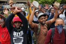 Students chant slogans as they carry rocks during clashes with the South African police at Johannesburg's University of the Witwatersrand, South Africa, October 4, 2016. PHOTO BY REUTERS/Siphiwe Sibeko