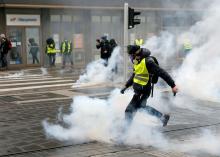 A protester returns a tear gas canister during a demonstration of the "yellow vests" movement in Strasbourg, France, January 12, 2019. PHOTO BY REUTERS/Vincent Kessler