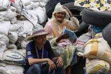 Anti-government protesters sit behind a barricade near Government Complex in Bangkok