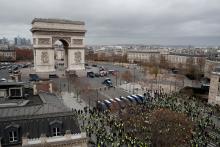 PARIS (Reuters) - Anti-government protesters faced off with French riot police in Paris on Saturday, hurling projectiles, torching cars and vandalizing shops and restaurants in a fourth weekend of unrest that has shaken President Emmanuel Macron's authority.  Police used tear gas, water cannon and horses to charge protesters on roads fanning out from the Champs Elysees boulevard, but encountered less violence than a week ago, when the capital witnessed its worst unrest since the 1968 student riots.  As nigh