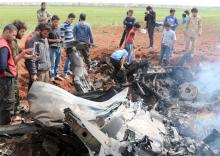 Rebel fighters and civilians gather around the wreckage of a Syrian warplane that was shot down in the Talat al-Iss area, south of Aleppo, Syria April 5, 2016. PHOTO BY REUTERS/Ammar Abdullah