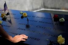 A person touches the south reflecting pool at the National September 11 Memorial and Museum on the 15th anniversary of the 9/11 attacks in Manhattan, New York, U.S., September 11, 2016. PHOTO BY REUTERS/Andrew Kelly