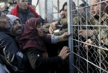 Syrian refugees struggle to enter Macedonia through a narrow border crossing as Macedonian policemen try to shut a metal gate near to the Greek village of Idomeni, December 4, 2015. PHOTO BY REUTERS/Yannis Behrakis