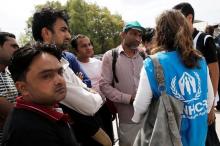 Refugees and migrants are briefed by a United Nations High Commissioner for Refugees (UNHCR) staff (L) before a pre-registration process that gives them access to the asylum procedure, at the premises of the disused Hellenikon airport, in Athens, Greece, June 13, 2016. PHOTO BY REUTERS/Alkis Konstantinidis