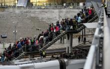 Police organize a line of refugees on a stairway leading up to trains arriving from Denmark at the Hyllie train station outside Malmo, Sweden, November 19, 2015. PHOTO BY REUTERS/Johan Nilsson