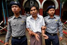 Detained Reuters journalist Kyaw Soe Oo is escorted by police officers as he leaves Insein court in Yangon, Myanmar, July 30, 2018. PHOTO BY REUTERS/Stringer
