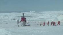 Rescue workers make their way from a helicopter to the Russian ship Akademik Shokalskiy, which has been trapped in Antarctic ice since Christmas Eve, at Commonwealth Bay in East Antarctica