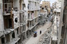 Residents walk near damaged buildings in Aleppo, Syria, May 5, 2016. PHOTO BY REUTERS/Abdalrhman Ismail