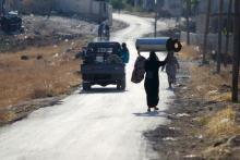 Residents walk on a street after fighters from a coalition of rebel groups called "Jaish al Fateh", also known as "Army of Fatah" (Conquest Army), captured Zeyzoun thermal station from forces loyal to Syria's President Bashar al-Assad, activists said, in al-Ghab plain in the Hama countryside July 29, 2015. REUTERS/Ammar Abdullah