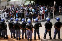 Riot police officers keep watch as students chant slogans outside the Hillbrow magistrate court during an appearance of their colleagues who were arrested during a protest demanding free education at the Johannesburg's University of the Witwatersrand, South Africa, October 12, 2016. PHOTO BY REUTERS/Siphiwe Sibeko