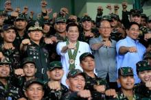 Philippines President Rodrigo Duterte (C) clenches fist with members of the Philippine Army during his visit at the army headquarters in Taguig city, metro Manila, Philippines, October 4, 2016. PHOTO BY REUTERS/Romeo Ranoco