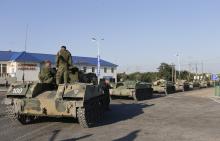 Russian military personnel sit atop armoured vehicles outside Kamensk-Shakhtinsky, Rostov Region