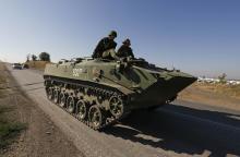 Russian servicemen drive a military vehicle along a road outside Kamensk-Shakhtinsky near the border with Ukraine, Rostov Region