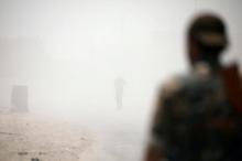 Syrian Democratic Forces (SDF) fighters stand amid smoke in Raqqa's western neighbourhood of Jazra, Syria June 11, 2017. PHOTO BY REUTERS/Rodi Said